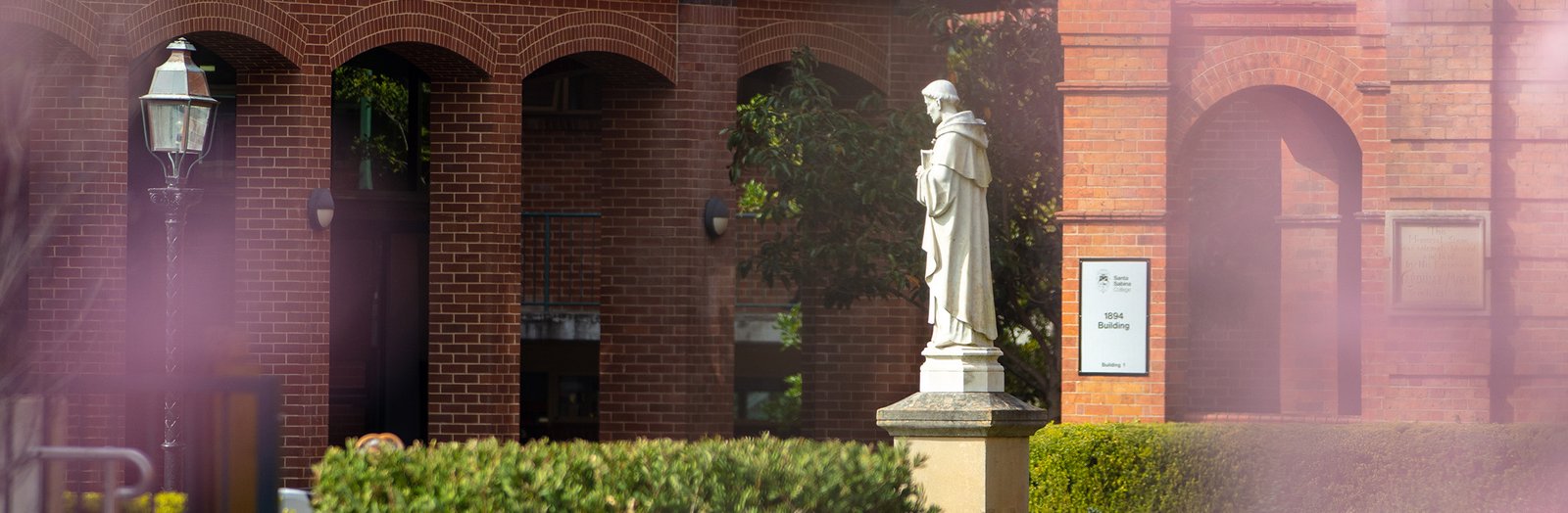Statue with school grounds in the background.