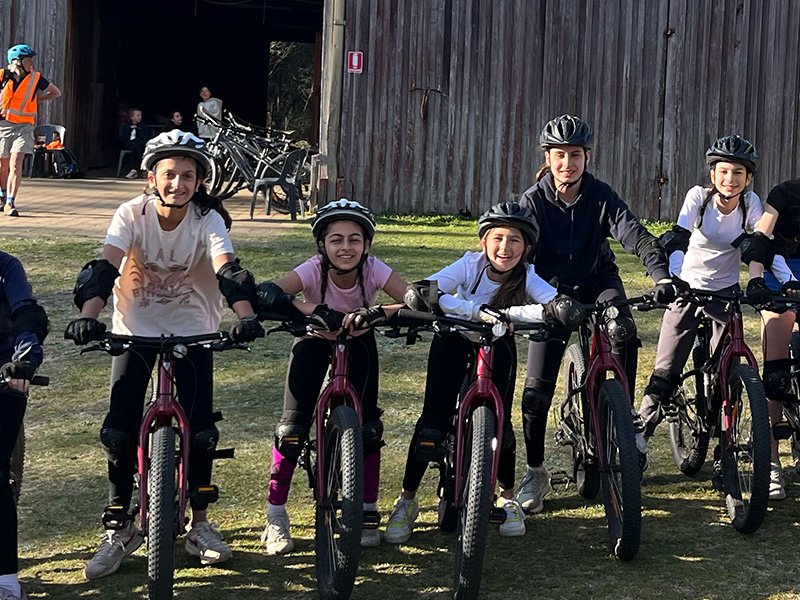 Students smiling together, ready to ride bikes.