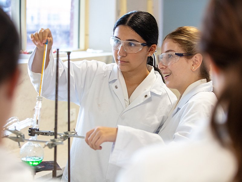Two high school students conducting a science experiment in class.
