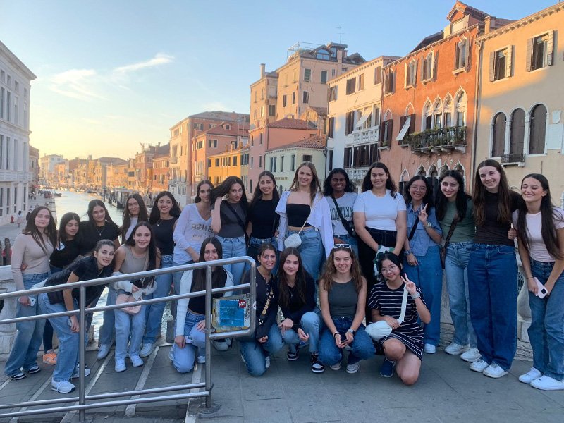 Group of high school students smiling together overseas.