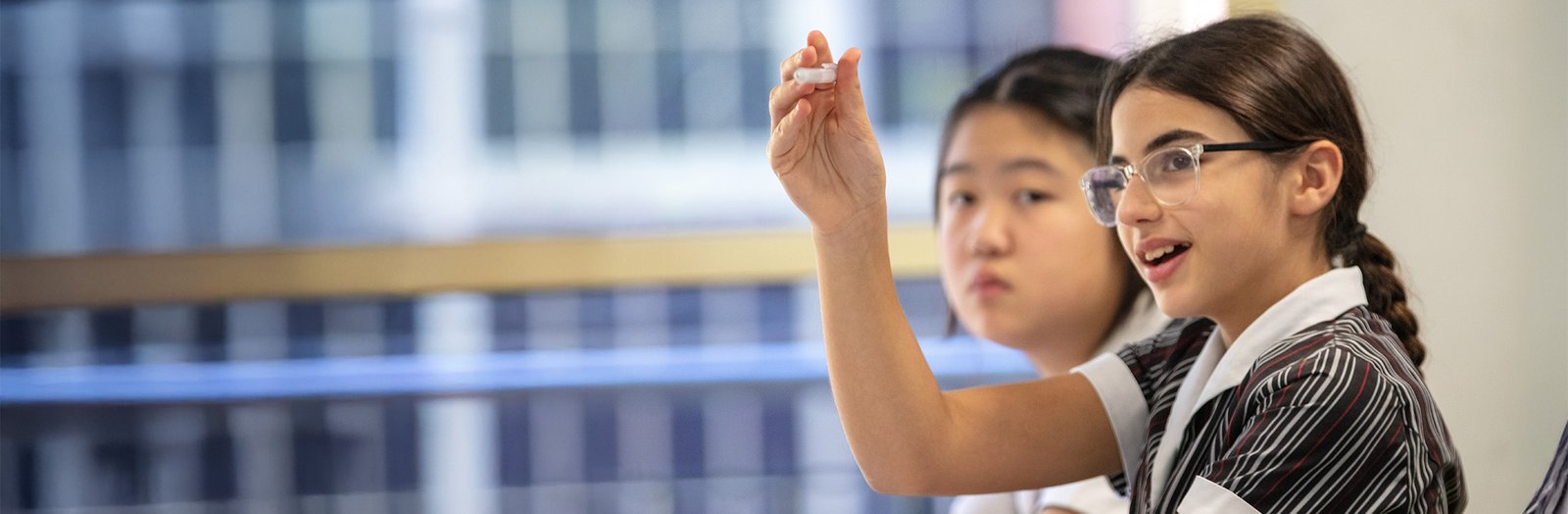 Student raising their hand in homeroom class.
