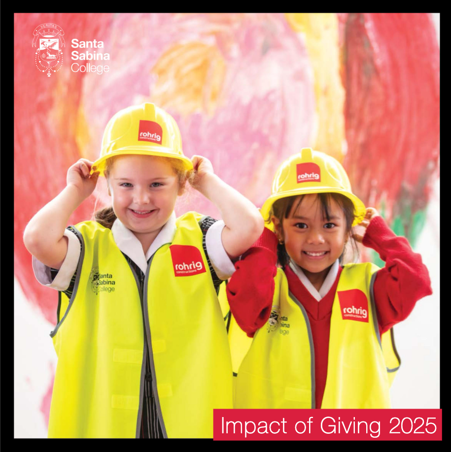 Two primary school students wearing high-vis vests and hard hats, smiling.